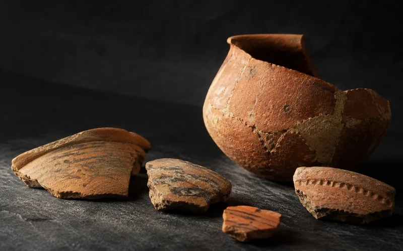 Ancient terracotta vessel and fragments — illustrative