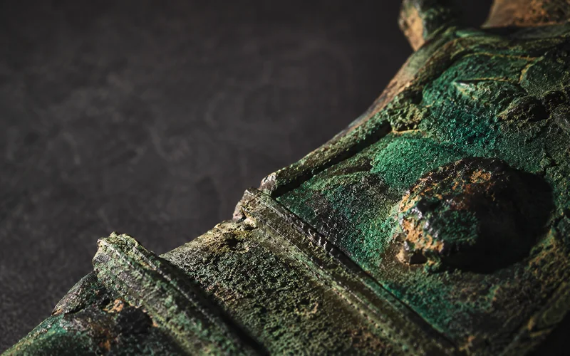 Corroded ancient bronze with verdigris patina — illustrative